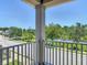 A view from the balcony that overlooks the street and a scenic pond surrounded by trees at 4630 Socrates Way, Sanford, FL 32773