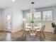 Bright dining area with modern round table, white chairs, stylish pendant lighting, and wood-look floors at 4630 Socrates Way, Sanford, FL 32773