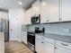 Updated kitchen featuring stainless steel appliances, granite countertops, subway tile backsplash, and white cabinets at 4630 Socrates Way, Sanford, FL 32773