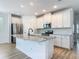 Modern kitchen featuring white cabinets, stainless steel appliances, large center island with granite countertop, and tile backsplash at 4630 Socrates Way, Sanford, FL 32773