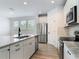 Modern kitchen featuring granite countertops, stainless steel appliances, white cabinetry, and wood-look flooring at 4630 Socrates Way, Sanford, FL 32773