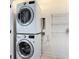 Efficient laundry area with stacked washer and dryer, plus a shelving unit for storage at 4630 Socrates Way, Sanford, FL 32773