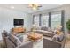 Cozy living room featuring neutral furniture, natural light, wood floors, and a contemporary ceiling fan at 4630 Socrates Way, Sanford, FL 32773