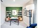 Stylish office with green accent wall, natural light, desk, modern shelving, and blue accent chair at 4742 Yellow Elder Way, Kissimmee, FL 34758