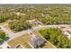 Aerial view of a modern home nestled among trees, highlighted by a red locator pin, near other homes at 501 Marion Oaks Golf Way, Ocala, FL 34473