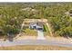Aerial shot of a modern single-story home in a serene, wooded location with a long, paved driveway at 501 Marion Oaks Golf Way, Ocala, FL 34473