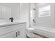 Stylish bathroom boasts marble tiled shower, a white vanity, black hardware, and wood-look flooring at 501 Marion Oaks Golf Way, Ocala, FL 34473