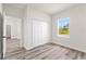 Bedroom with wood-look vinyl flooring, window, closet, and white walls at 501 Marion Oaks Golf Way, Ocala, FL 34473