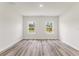 Bright bedroom with neutral paint, trim, and vinyl floors, with two windows showing trees at 501 Marion Oaks Golf Way, Ocala, FL 34473