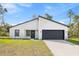 Charming single-story home featuring a modern white facade, black trim, and an attached two-car garage at 501 Marion Oaks Golf Way, Ocala, FL 34473
