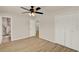 Spacious bedroom with wood floors, a ceiling fan, closet doors and view to bathroom at 5210 Poinsetta Ave, Winter Park, FL 32792