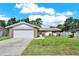 Charming single-story home featuring brick accents, a two-car garage, and a well-manicured lawn at 5210 Poinsetta Ave, Winter Park, FL 32792