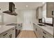 Updated kitchen featuring quartz countertops, modern cabinetry, stainless steel appliances, and a sleek black backsplash at 5210 Poinsetta Ave, Winter Park, FL 32792