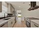 Modern kitchen with grey cabinets, quartz countertops, stainless steel appliances, and wood-look vinyl plank flooring at 5210 Poinsetta Ave, Winter Park, FL 32792