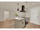 Open kitchen design featuring an island with an electric cooktop, modern cabinets, and wood-look vinyl plank flooring at 5210 Poinsetta Ave, Winter Park, FL 32792