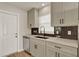 Bright kitchen showcasing a stainless steel dishwasher, quartz countertops, and sleek black hardware against neutral cabinets at 5210 Poinsetta Ave, Winter Park, FL 32792