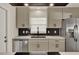 A modern kitchen featuring grey cabinets, stainless steel appliances, and a black backsplash at 5210 Poinsetta Ave, Winter Park, FL 32792