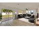 Bright living room with sleek gray sectional, modern décor, and sliding door to backyard at 5210 Poinsetta Ave, Winter Park, FL 32792