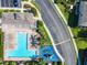 Aerial view of community pool, playground, and parking area amid lush landscaping and nearby street at 5420 Windsor Lake Cir, Sanford, FL 32773