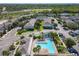 Aerial view of community pool, playground, parking area amid lush landscaping and homes in the distance at 5420 Windsor Lake Cir, Sanford, FL 32773