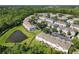 Aerial view of a townhouse community, featuring lush trees and a pond at 5420 Windsor Lake Cir, Sanford, FL 32773