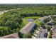 Aerial view of homes, parking and pond surrounded by lush green trees and foliage at 5420 Windsor Lake Cir, Sanford, FL 32773
