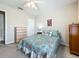 Bright bedroom featuring a bed with floral comforter, a wooden dresser, and a ceiling fan at 5420 Windsor Lake Cir, Sanford, FL 32773