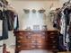 Walk-in closet with custom shelving, wooden dresser, and clothing racks for organization at 5420 Windsor Lake Cir, Sanford, FL 32773