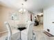 Bright dining area features a glass table with upholstered chairs and a view into the front entry at 5420 Windsor Lake Cir, Sanford, FL 32773