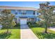 Charming townhome featuring a well-maintained lawn, attached garage, and attractive blue and beige exterior paint at 5420 Windsor Lake Cir, Sanford, FL 32773