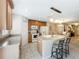 Open kitchen with island seating, wooden cabinets, and modern white appliances at 5420 Windsor Lake Cir, Sanford, FL 32773