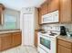 Cozy kitchen featuring modern appliances, wooden cabinets, and durable tile flooring at 5420 Windsor Lake Cir, Sanford, FL 32773