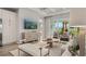 Bright living room with tray ceiling, modern furnishings, and sliding glass doors to the outdoor living area at 570 Hammock Oaks Blvd, Lady Lake, FL 32159