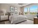 Serene bedroom with a large window, plush bedding, ambient lighting, and modern decor creating a relaxing retreat at 570 Hammock Oaks Blvd, Lady Lake, FL 32159