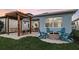 Charming outdoor space with a fire pit, Adirondack chairs, and a pergola-covered dining area at 570 Hammock Oaks Blvd, Lady Lake, FL 32159