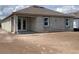 Unfinished single-story home showcasing concrete block construction and a covered patio with double doors at 5706 Cattle Ranch Drive, St Cloud, FL 34771