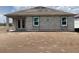 Rear exterior view of an unfinished house featuring a block construction, windows, and a covered patio at 5706 Cattle Ranch Drive, St Cloud, FL 34771