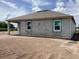 Unfinished house featuring concrete block construction, windows, covered patio, and a partially grassy yard at 5706 Cattle Ranch Drive, St Cloud, FL 34771