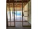 Unfinished interior with exposed wood framing and concrete block walls, leading to an outdoor view at 5706 Cattle Ranch Drive, St Cloud, FL 34771