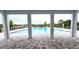View of a beautiful community swimming pool framed by architectural columns and patterned brick at 5706 Cattle Ranch Drive, St Cloud, FL 34771