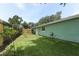 Well-maintained backyard with a green lawn, wooden fence, and access door to the house at 645 Peachwood Dr, Altamonte Springs, FL 32714
