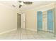 This bedroom features tile floors, a ceiling fan, and a mirrored closet with custom shelving and drawers at 645 Peachwood Dr, Altamonte Springs, FL 32714