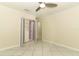 This bedroom includes neutral walls, tile flooring, ceiling fan, and a closet with mirrored doors at 645 Peachwood Dr, Altamonte Springs, FL 32714