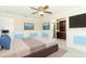 Bedroom featuring wainscoting, neutral walls, tile floors, a ceiling fan, and closet access at 645 Peachwood Dr, Altamonte Springs, FL 32714