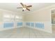 Light filled living room with tile flooring, blue paneled walls, and ceiling fan at 645 Peachwood Dr, Altamonte Springs, FL 32714