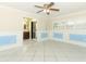 Living room with tile flooring and blue paneled walls next to a bathroom with dark wood cabinets at 645 Peachwood Dr, Altamonte Springs, FL 32714