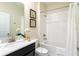 Well-lit bathroom with a single sink vanity, framed mirror, and a shower-tub combination with white tile surround at 671 Drop Shot Dr, Davenport, FL 33896