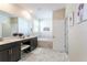 Spacious bathroom with double vanity, a soaking tub, and marble tile flooring at 671 Drop Shot Dr, Davenport, FL 33896
