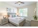 Comfortable bedroom with a queen-size bed, soft lighting, and a window offering a view of the outdoors at 671 Drop Shot Dr, Davenport, FL 33896