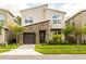Modern two-story home showcasing a stone accent wall, well-maintained landscaping, and a single-car garage at 671 Drop Shot Dr, Davenport, FL 33896